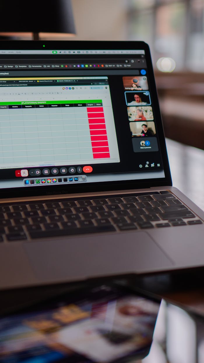 Laptop displaying a remote video meeting in a modern office setting.